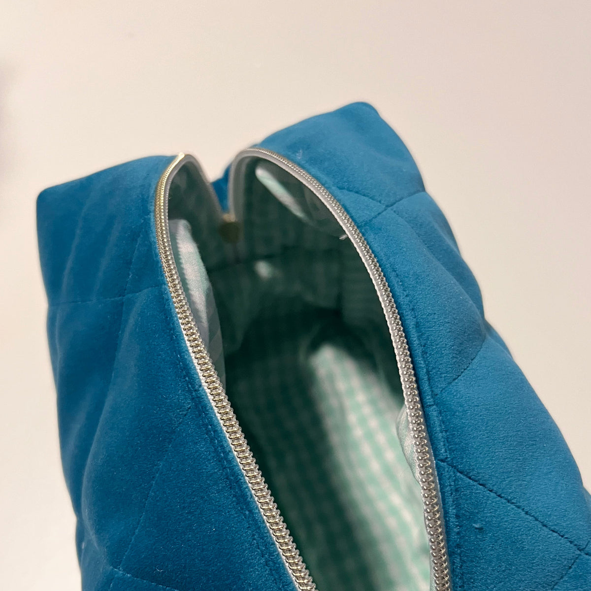 blue velvet makeup bag with light green gingham lining