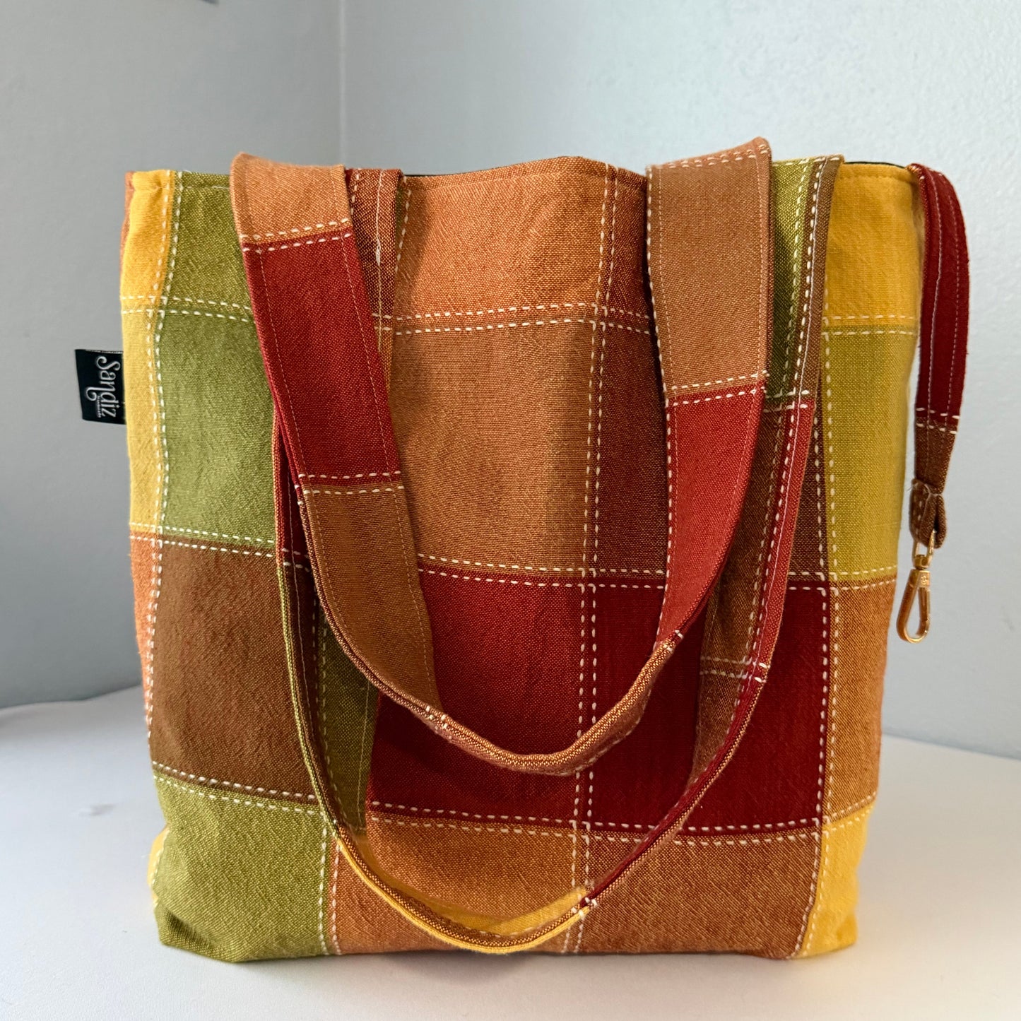 Multicolored patchwork bag with a visible brand label on a light gray background