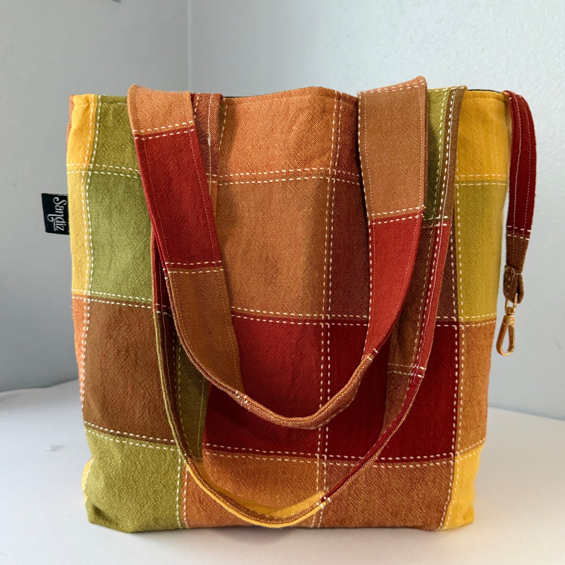 Multicolored patchwork bag with a visible brand label on a light gray background