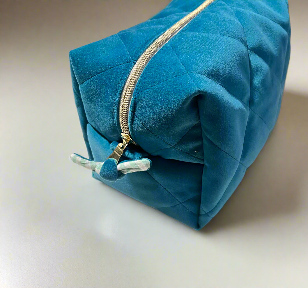 gold zipper and blue ribbon detail on velvet makeup pouch